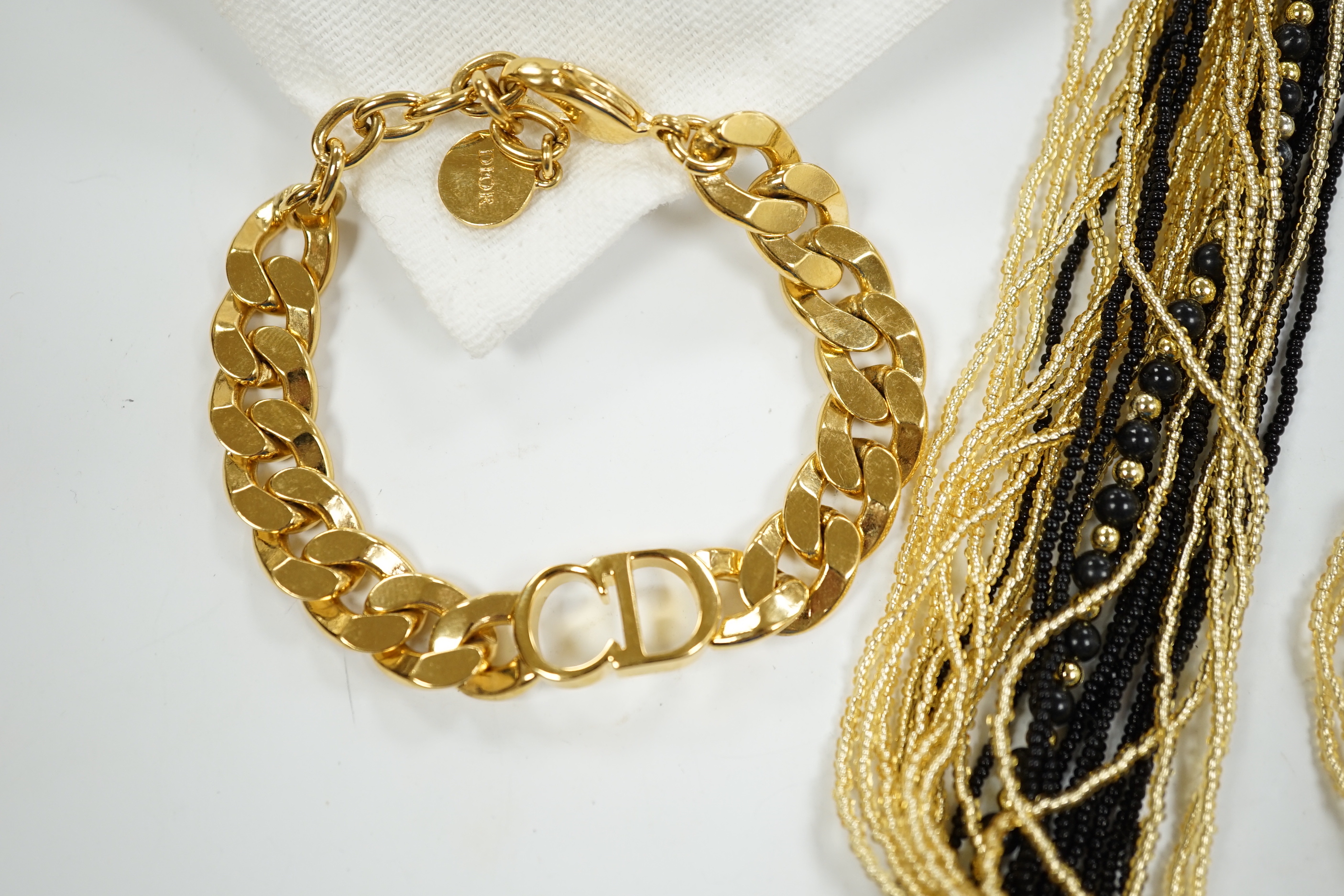 A Christian Dior Danseuse Etoile gilt bracelet, 18cm, with Dior box and pamphlet etc. together with a Luciani Murano glass bead twist necklace, 48cm.